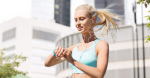 Young blonde woman looking at a fitness tracker