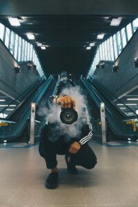 man with a camera obscured by smoke in front of escalators