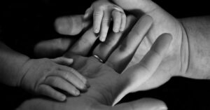a baby's hands in an adults hands