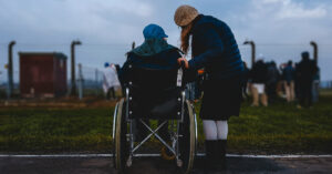 a person talking to another person in a wheelchair
