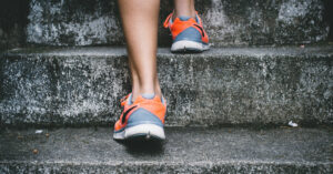 a person in running shoes going up steps