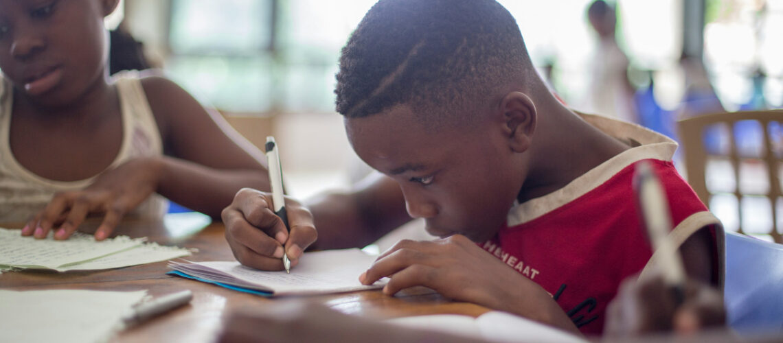 two children in school writing a test