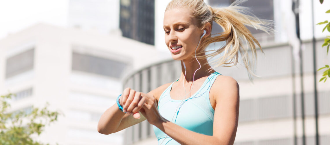 Young blonde woman looking at a fitness tracker