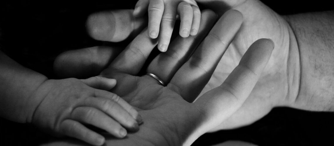 a baby's hands in an adults hands
