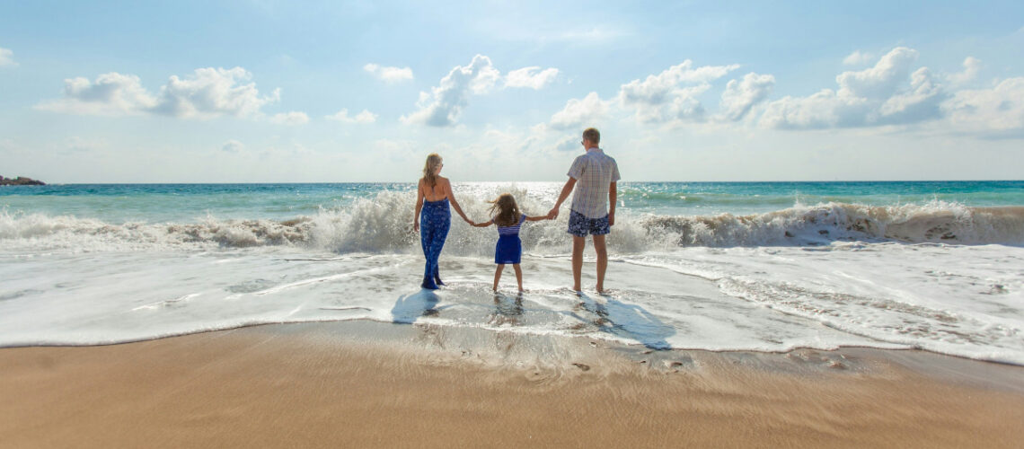 a family holding hands on a beach