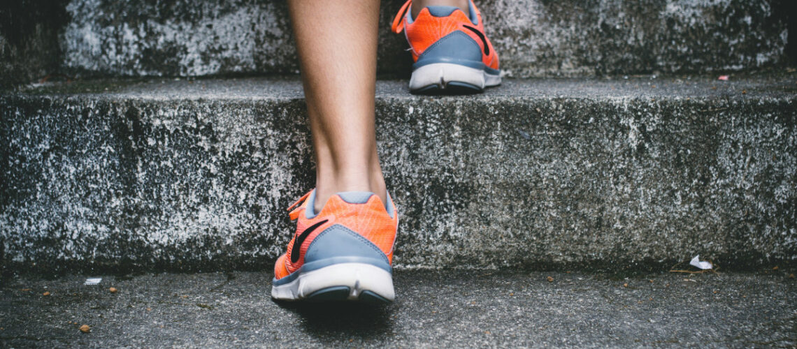 a person in running shoes going up steps
