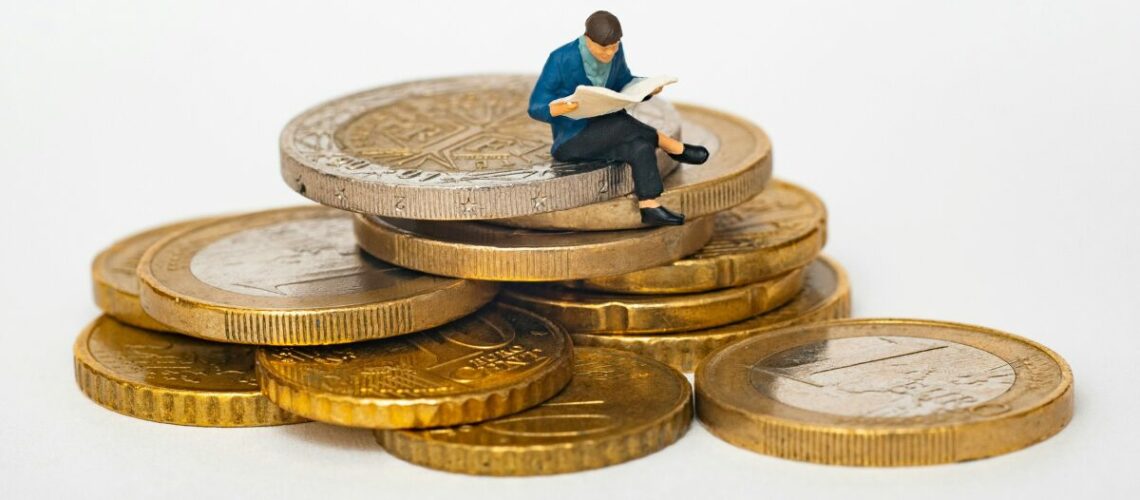 investment graphic of a man sitting on coins