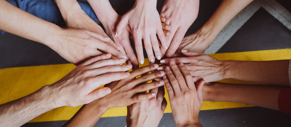 A diverse group of people reaching their hands out to one another