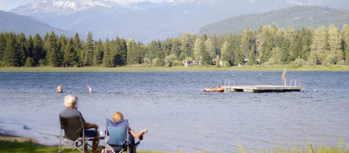 two people sitting looking out over a lake