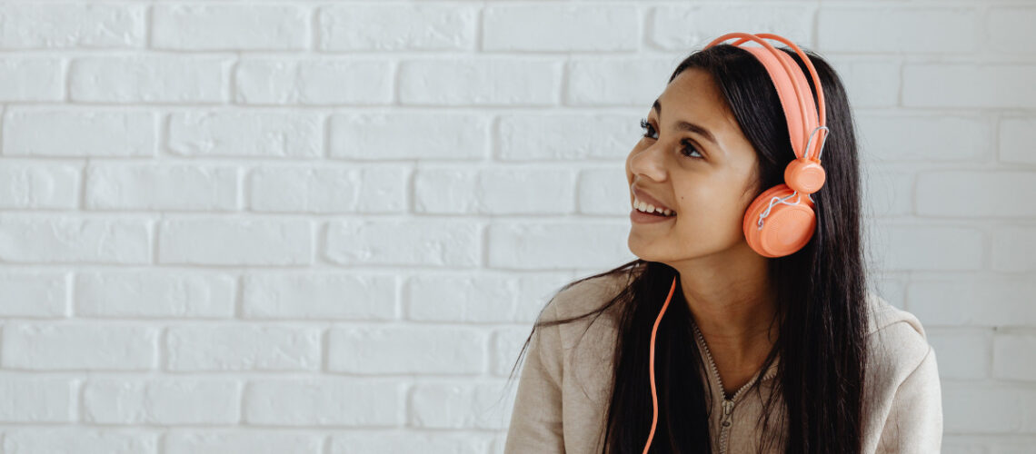 Adolescent girl wearing orange headphones