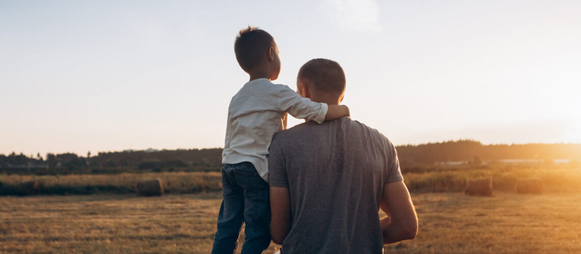 Father and son playing in the park at the sunset time. Family, trust, protecting, care, parenting, summer vacation concept