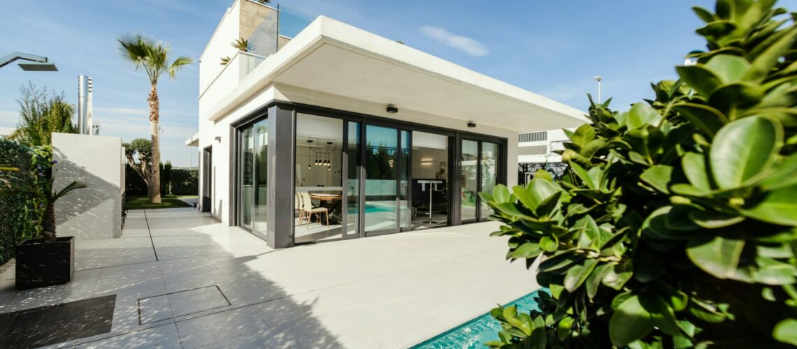 white and grey concrete building near swimming pool under clear sky during daytime