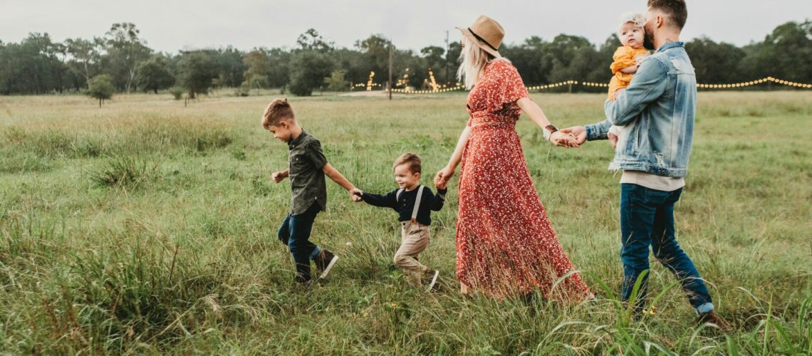 woman holding man and toddler hands during daytime