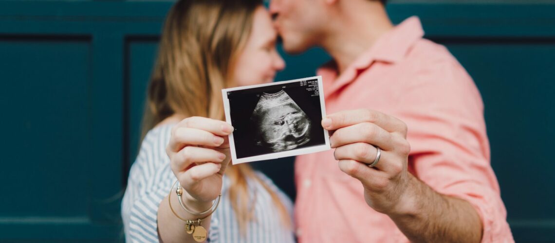 Couple holding a picture of a pregnancy